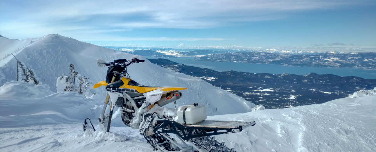 Snowmobile parked overlooking snowy mountain